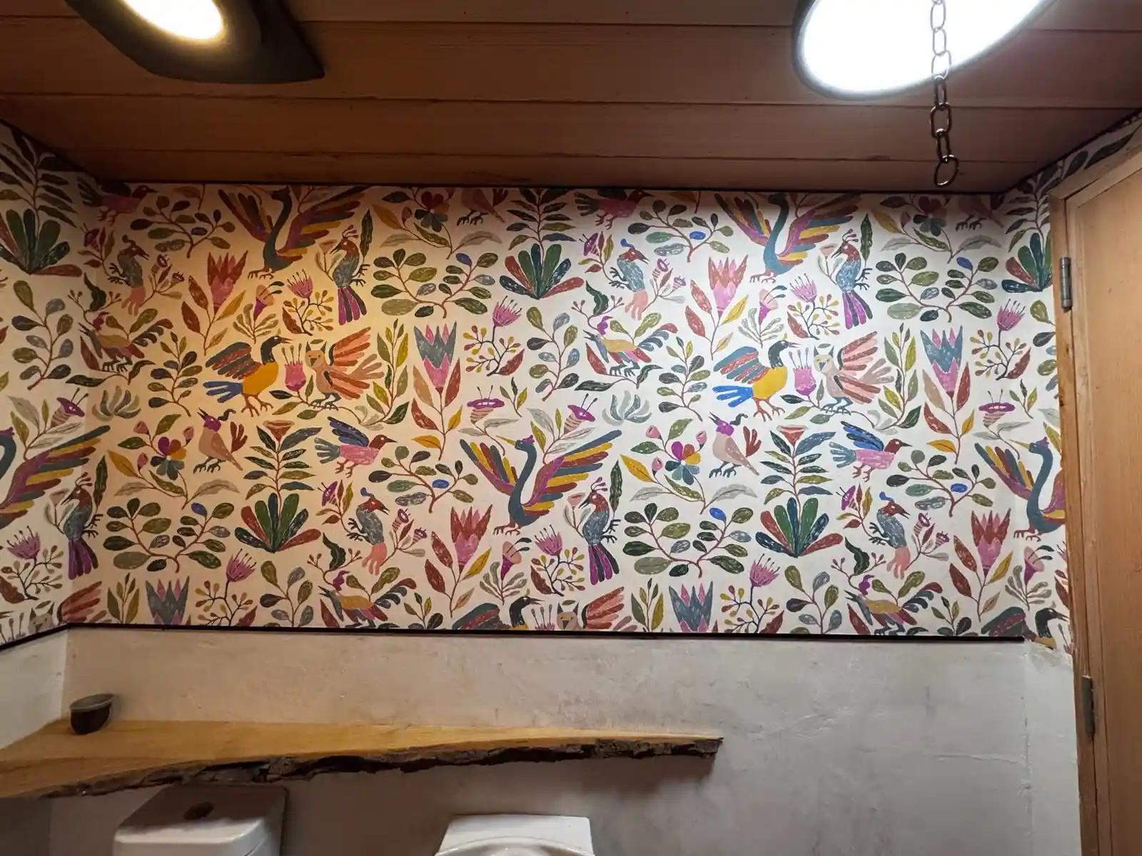 A leafy wallpaper pattern used across a bright feature wall